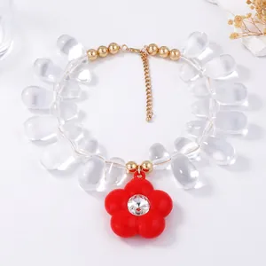 Macro view of transparent teardrop beads and a red flower pendant with a sparkling crystal