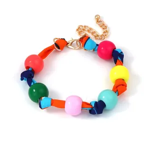 Close-up of colorful round beads with striped woven rope and gold lobster clasp