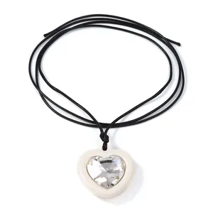 Détail du pendentif en forme de cœur avec pierre de zircon et cordon noir en cuir