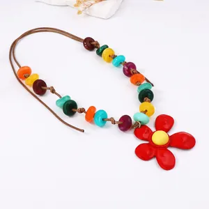 Collana di perline colorate stile bohémien con pendente a fiore rosso su sfondo bianco