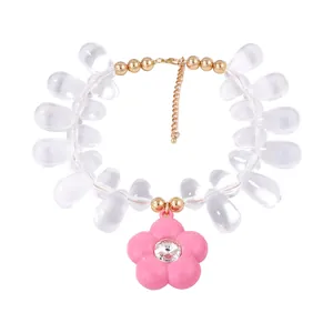 Colorful beaded necklace featuring clear teardrop beads and a pink flower charm pendant