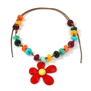 Collana di perle colorate stile bohémien con un grande ciondolo a fiore rosso vivo