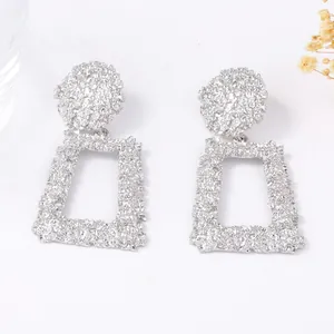 Boucles d'oreilles géométriques argentées avec relief floral et design rectangulaire
