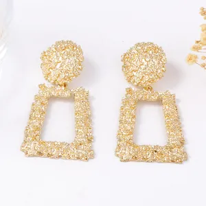 Boucles d'oreilles géométriques dorées avec relief floral et pendentifs rectangulaires