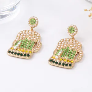 Detailed macro view of creative beer mug earrings with green rhinestones and pearl foam