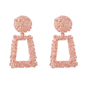 Détails de boucles d'oreilles géométriques en or rose avec finition relief texturée