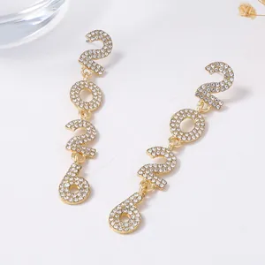 Detailed view of long 2026 number earrings with sparkling rhinestones on gold alloy base
