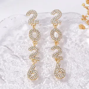 Detailed view of 2026 number drop earrings with rhinestones on textured ice background
