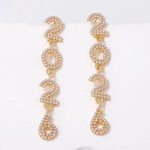 Elegant gold-toned 2026 year drop earrings studded with white faux pearls for women.