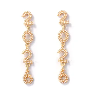 Detail of 2026 drop earrings featuring gold metal alloy and white pearl inlay