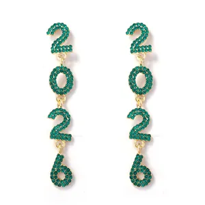 Close-up of gold 2026 number earrings with sparkling green rhinestones and fine details