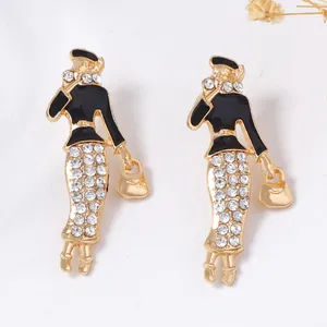 Dettaglio degli orecchini da donna con smalto nero e strass luminosi su fondo bianco
