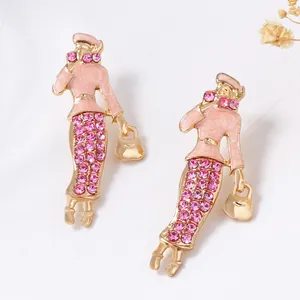 Dettaglio ravvicinato di orecchini vintage con smalto rosa e strass scintillanti