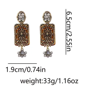 Detail of vintage palace style earrings with amber resin and geometric rhinestones
