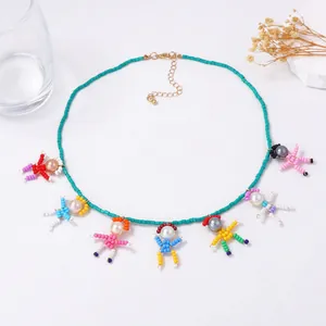 Handmade necklace with colorful bead doll pendants and pearl heads on a green beaded chain