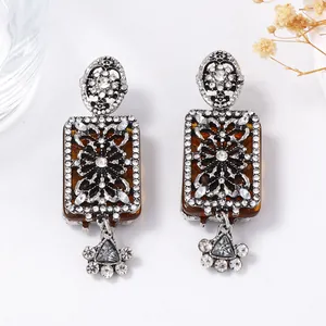 Vintage Baroque floral drop earrings with amber resin and sparkling crystals on white background