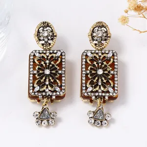 Macro shot of vintage gold earrings with amber resin and sparkling crystals details