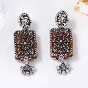 Detail of vintage palace style earrings with amber resin and sparkling rhinestones