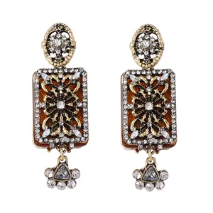 Detailed view of vintage gold-tone floral earrings with intricate rhinestones and amber resin