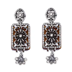 Detail of vintage palace style earrings with amber resin and floral rhinestone patterns