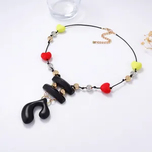 Retro geometric beaded necklace with red yellow hearts and abstract pendant on white background