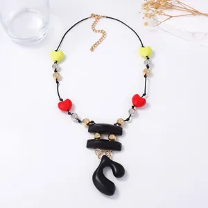 Artistic long necklace with colorful heart beads and abstract pendant on white background