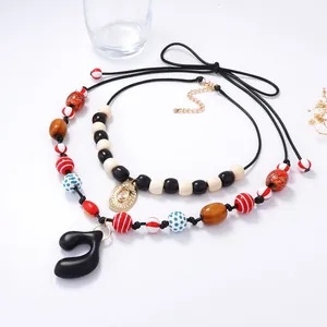 Bohemian double-layer beaded necklace with geometric pendants on a white desktop