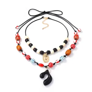 Double layered geometric beaded necklace with black music note pendant and sun charm