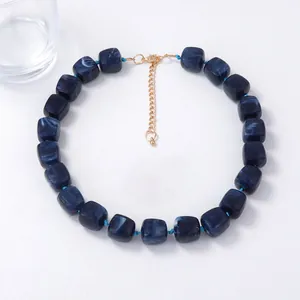 Detail of blue marble resin beads and gold-plated lobster clasp on the necklace