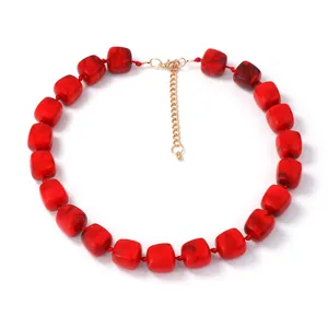Detail of red cube resin beads with marble texture and gold lobster clasp necklace