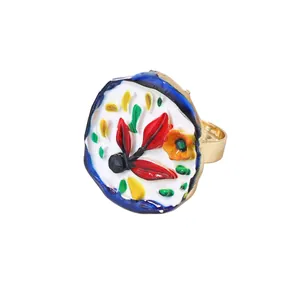 Nahaufnahme der floralen Emaille-Herz-Muster auf dem goldenen Legierungsring