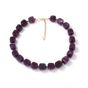 Macro detail of purple marble texture resin cube beads and gold clasp on necklace