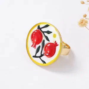 Nahaufnahme eines goldenen Vintage-Rings mit emailliertem Granatapfel-Muster