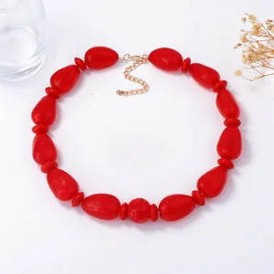 Elegante collar de grandes cuentas rojas ovaladas de resina con cadena de extensión dorada