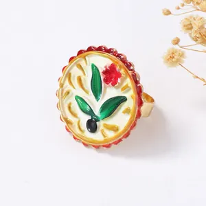 Detailaufnahme eines Vintage-Emaille-Rings mit Blumenmuster und gewelltem Rand