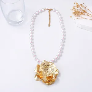 Collier de perles avec un grand pendentif fleur dorée martelée et fermoir mousqueton réglable