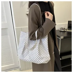Grand sac fourre-tout à motifs géométriques porté par un mannequin en blazer marron