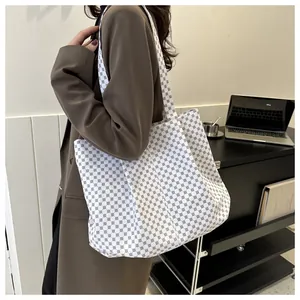 Détail d'un grand sac cabas à motif géométrique porté par un mannequin au bureau