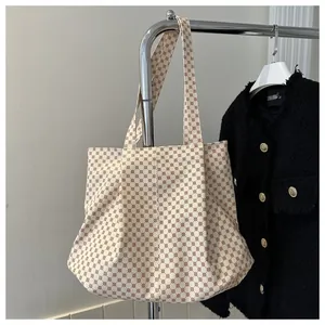 Détail du grand sac cabas en toile avec motif géométrique marron sur fond crème
