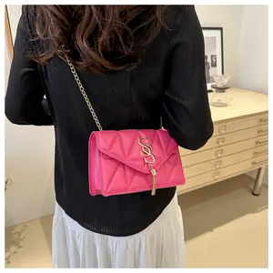 Magenta Umhängetasche mit Steppmuster, goldener S-Schnalle und Metallquaste am Modell