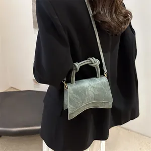 Retro light green faux leather crossbody bag with knotted handle and curved base