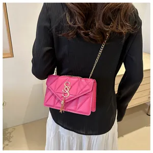 Detailaufnahme der pinkfarbenen gesteppten Ledertasche mit goldenem S-Logo und Quasten