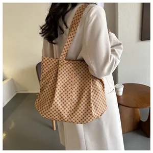 Vue de dos d'un mannequin portant un grand sac cabas avec motifs géométriques rétro