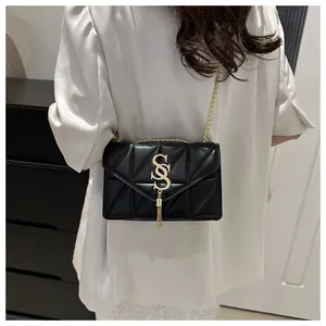Details der schwarzen Stepptasche mit goldenem SS-Logo und dekorativer Fransenquaste