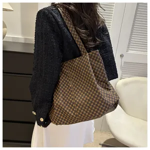 Détail d'un grand sac cabas vintage avec imprimés porté par un mannequin élégant