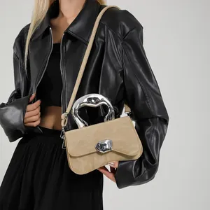 Modern beige leather crossbody bag with artistic silver metallic handle and buckle