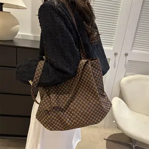 Grand sac cabas vintage marron avec motif géométrique porté à l'épaule avec élégance