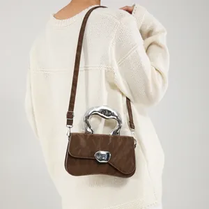 Brown pleated leather crossbody bag with irregular silver metal handle and lock