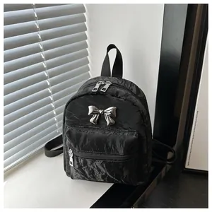 Macro shot of black pleated texture with silver metal bow and triple zipper detail