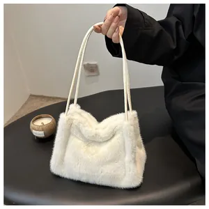 Close-up of white plush shoulder bag featuring soft faux fur texture and dual handles